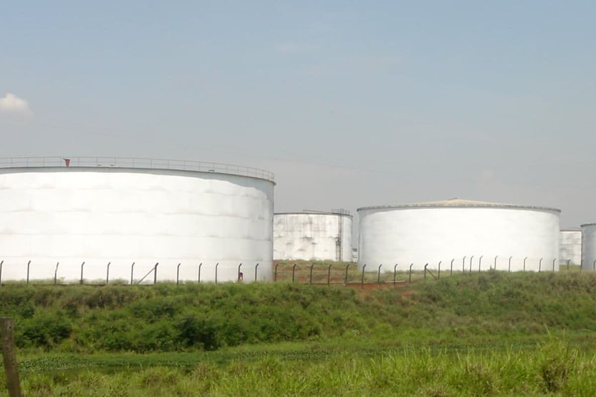 Grandes tanques brancos de armazenamento de etanol atrás de um gramado